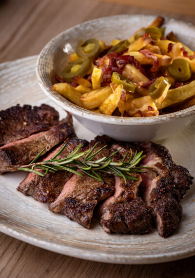 Rib eye steak házi hasábbal, cheddar mártással, jalapeñóval és roppanós szalonnával