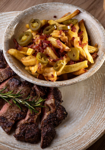 Rib eye steak házi hasábbal, cheddar mártással, jalapeñóval és roppanós szalonnával